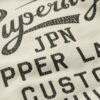 Crew-Sweatshirt mit Kupfer-Label-Grafik Crew-Sweatshirt mit Kupfer-Label-Grafik